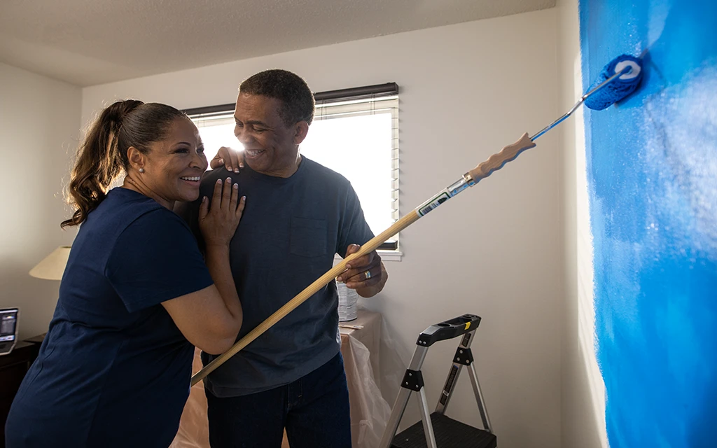 Couple painting a room together