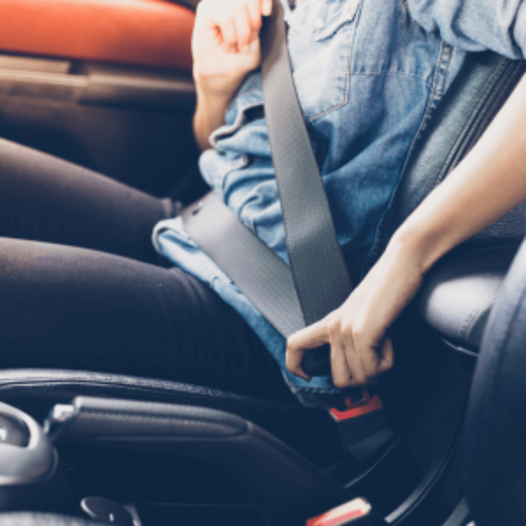 Lady puts on car seatbelt with a loan protected by Guaranteed Asset Protection (GAP)