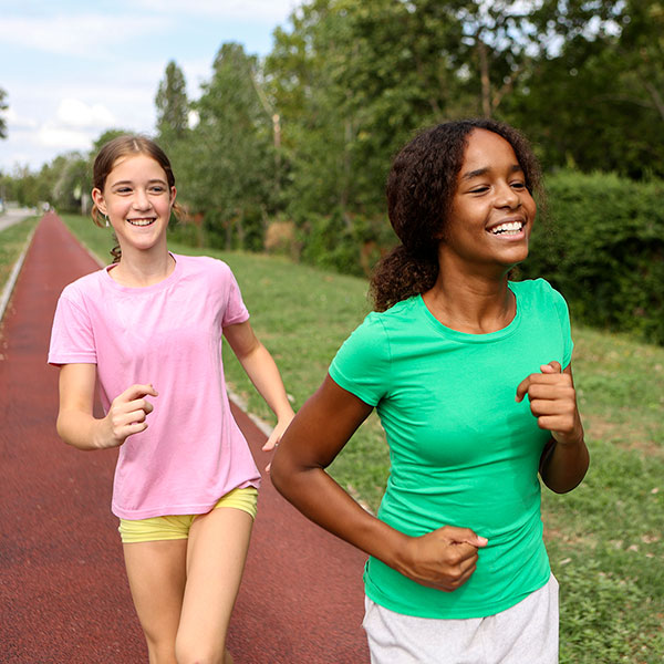 two girls running together outside